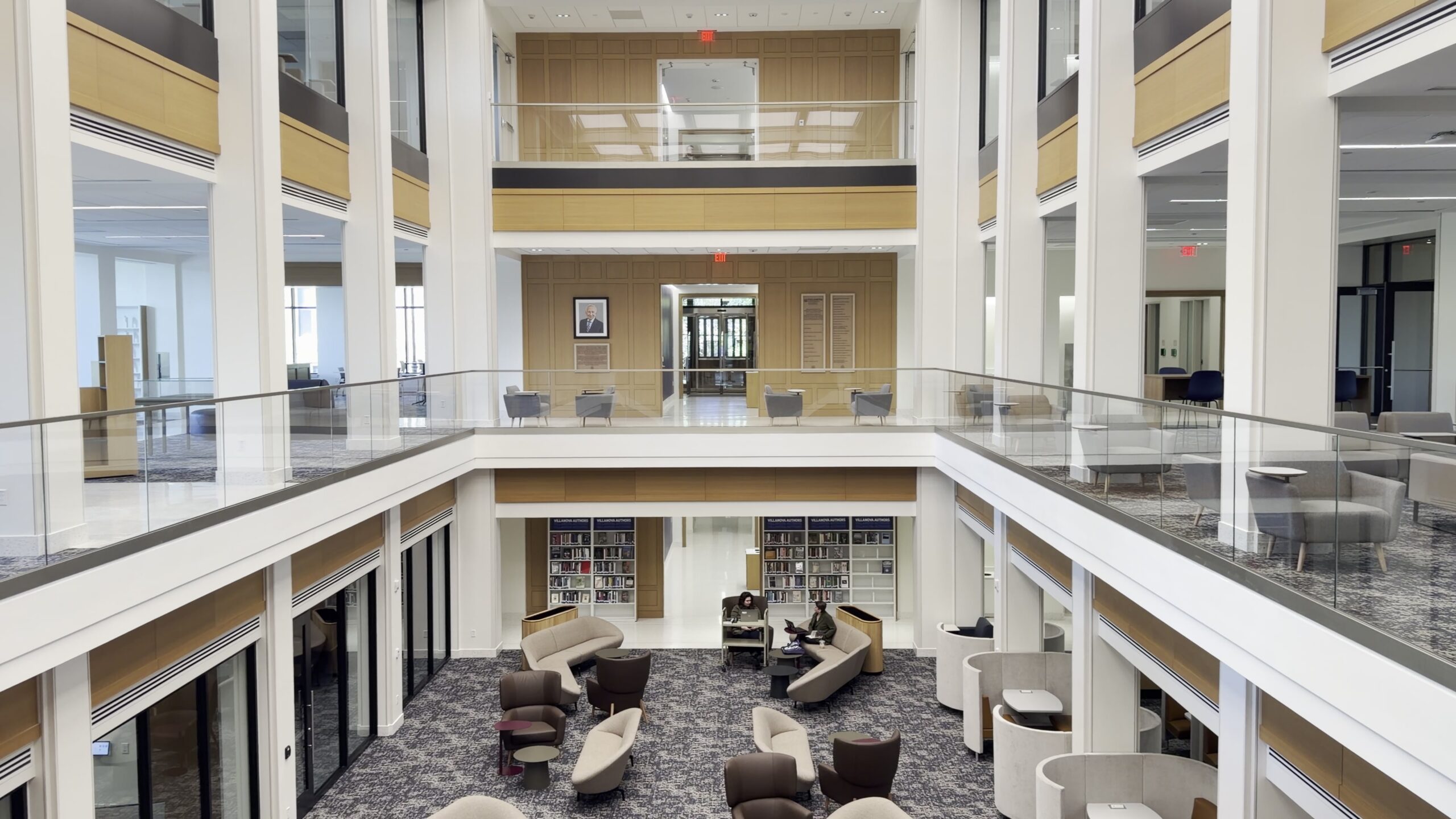 Multi-level library atrium at Villanova University lined with glass guardrails