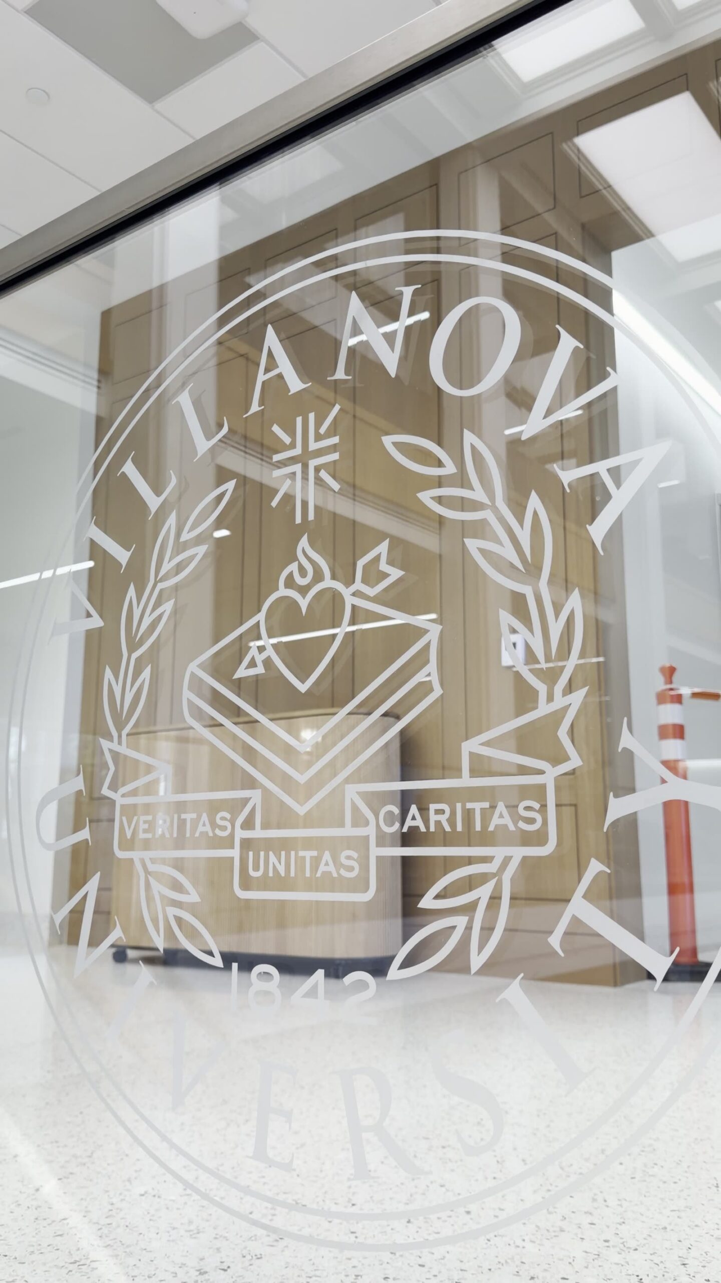 Close-up of the Villanova University acid-etched collegiate seal on a laminated glass guardrail panel