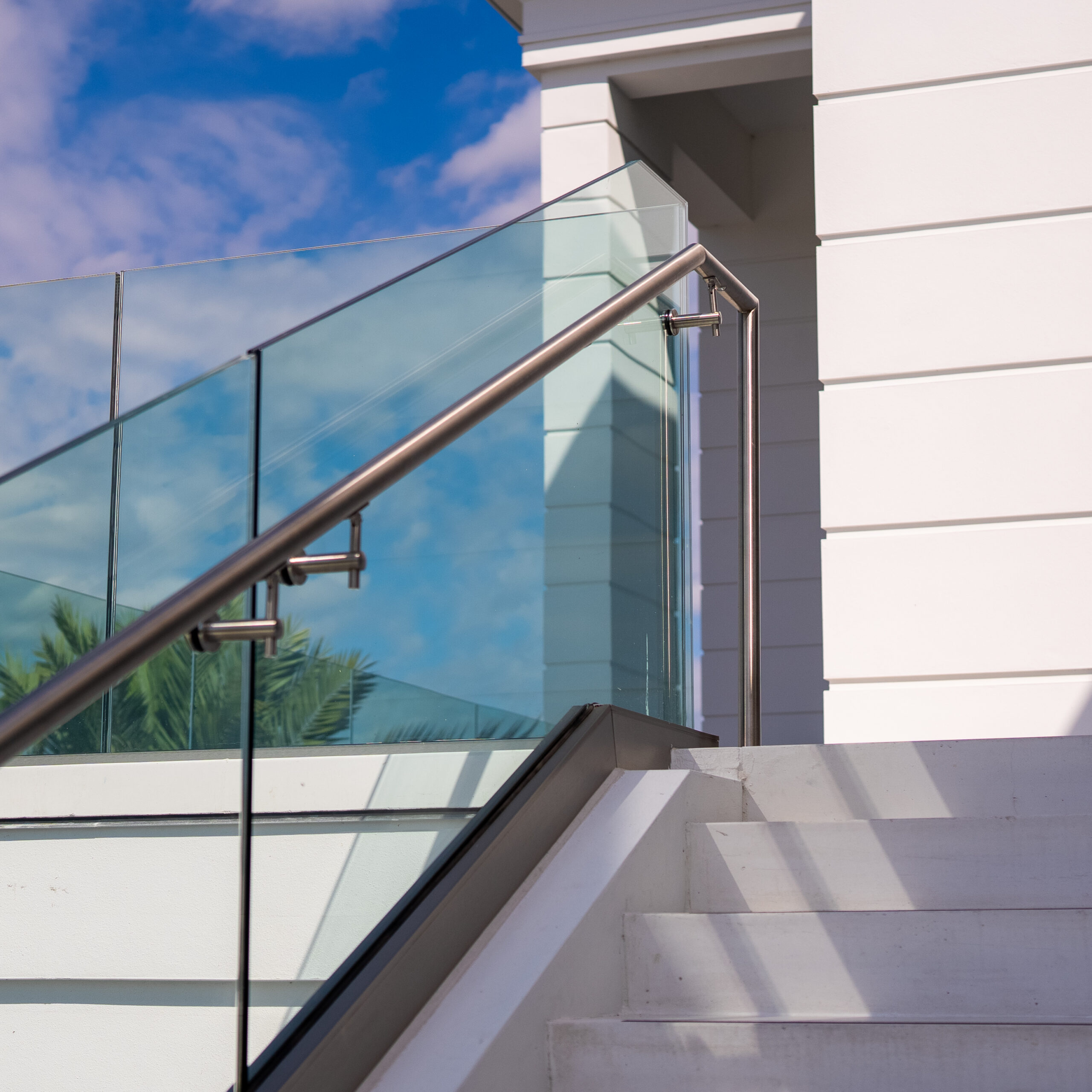 Close view of 42-inch laminated glass guardrail panels and handrail against the sky