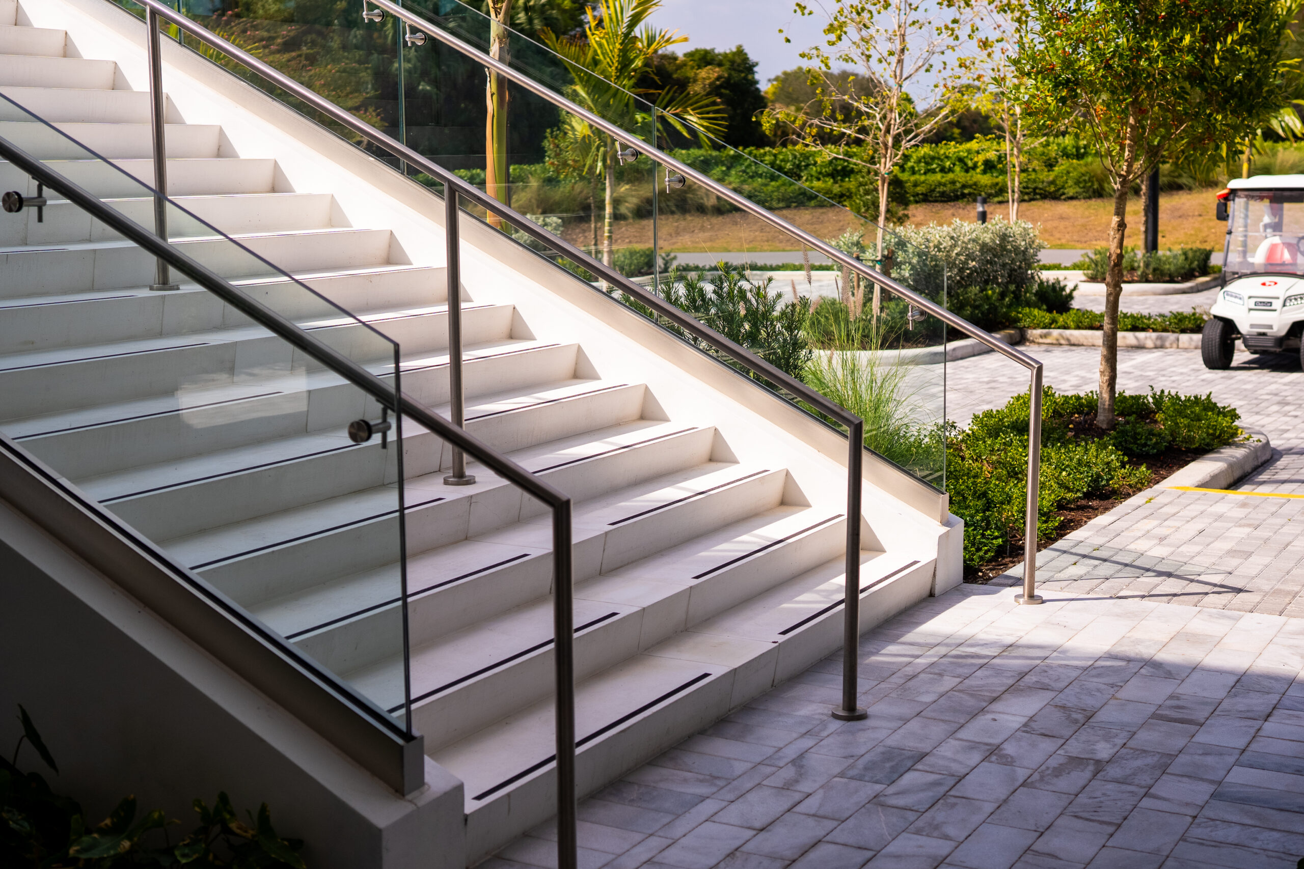 Frameless glass guardrail and stainless steel handrails on an exterior stair at the Frenchman's Creek clubhouse in Palm Beach Gardens, Florida