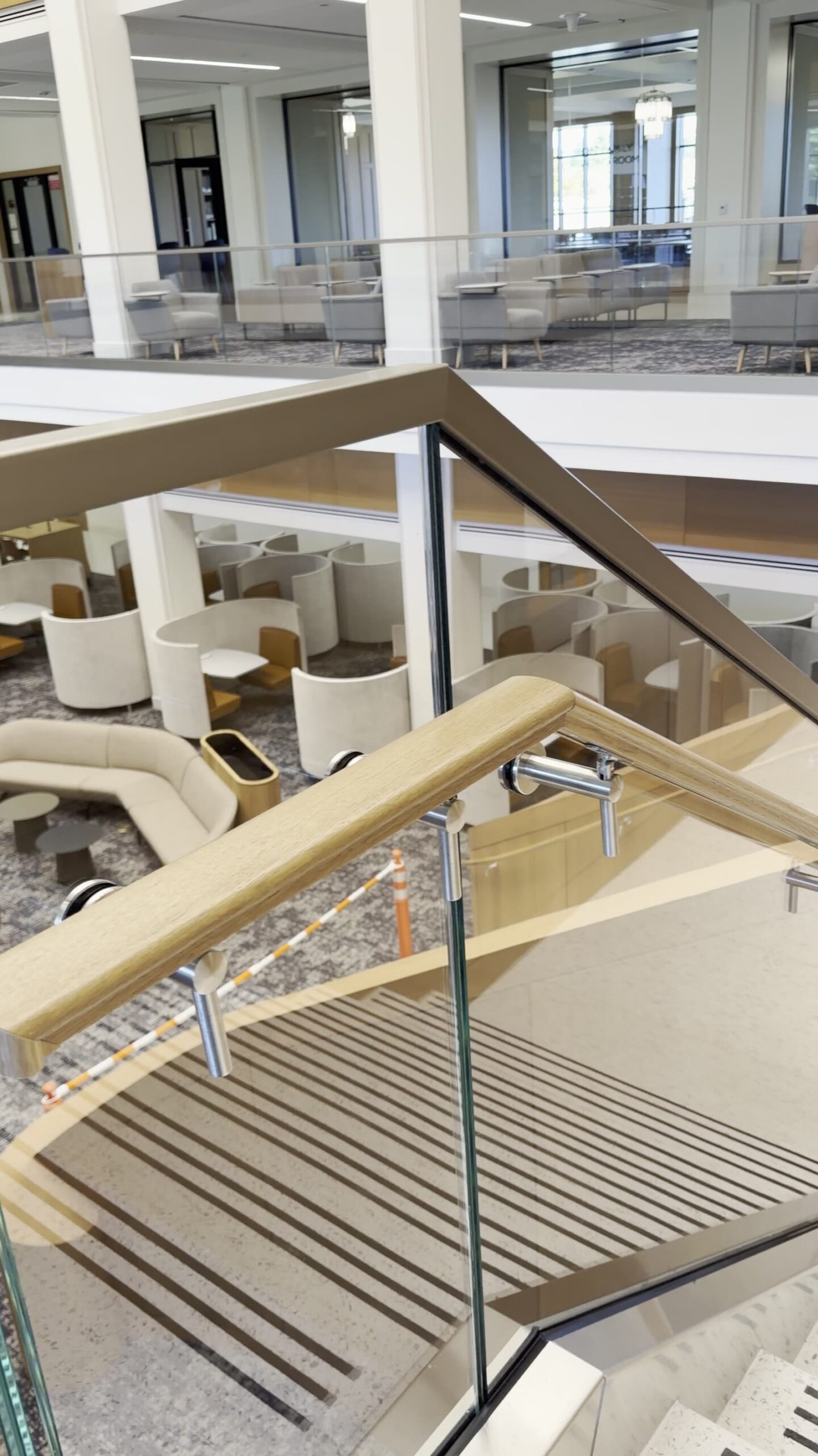 Brisk M12 laminated glass railing with top cap and handrail brackets at the library's monumental stair