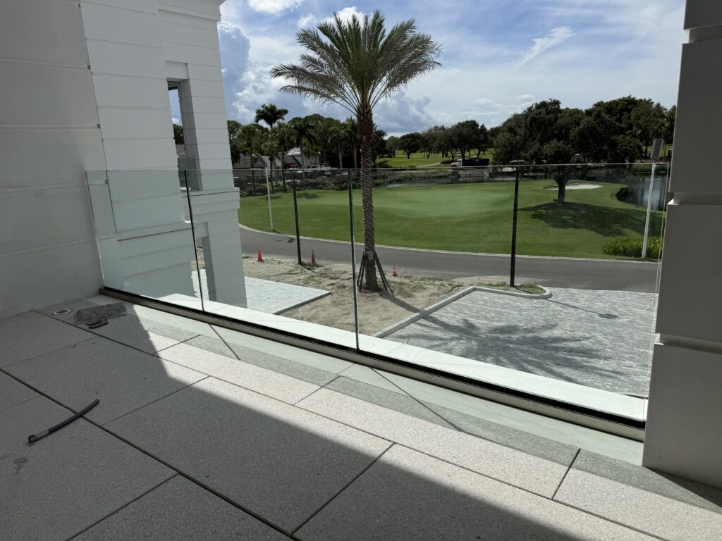 Brisk M10 balcony glass railing, engineered for hurricanes, overlooking the golf course at Frenchman's Creek