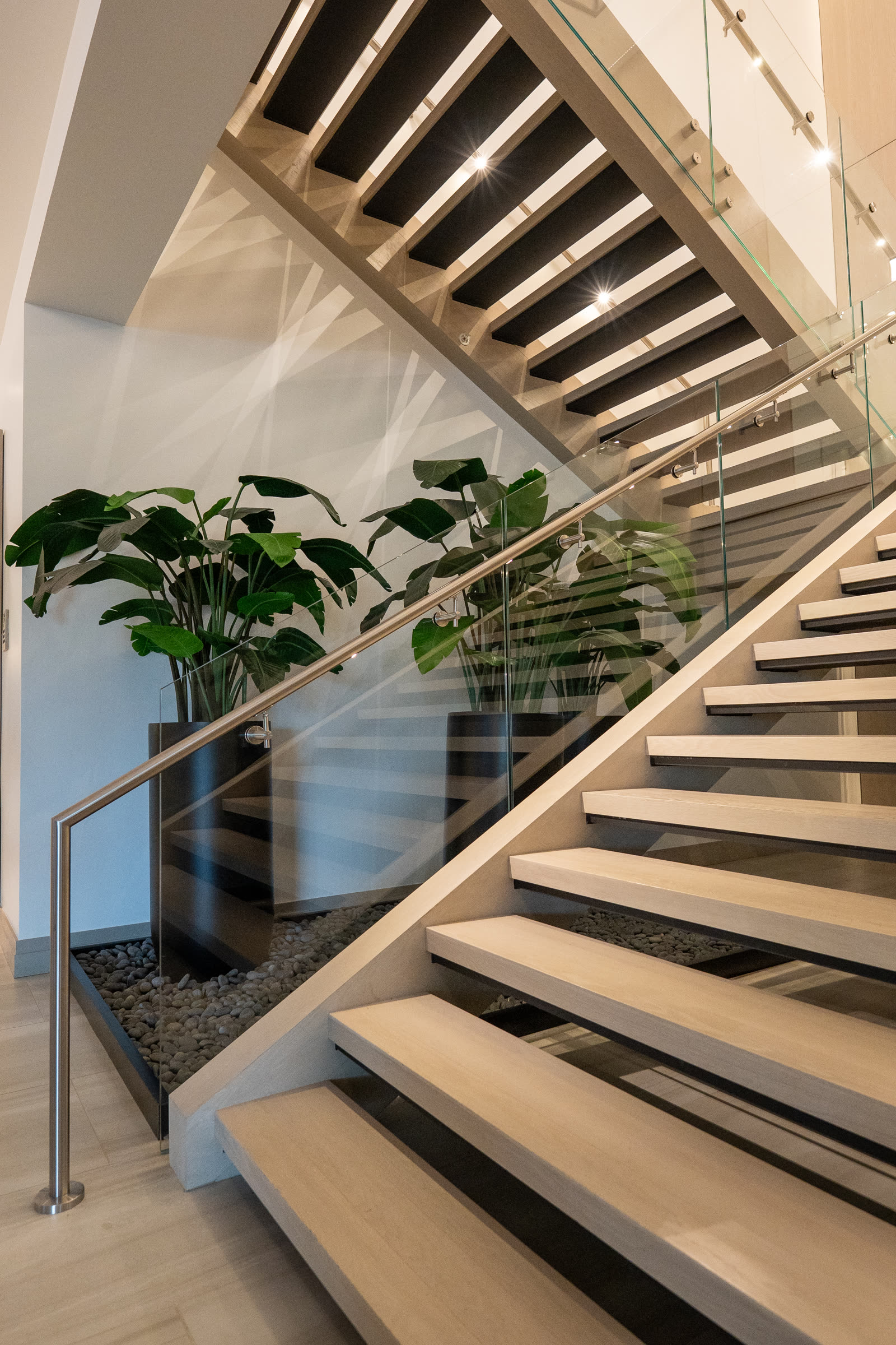 View up the clubhouse monument stair showing continuous glass railing and handrail