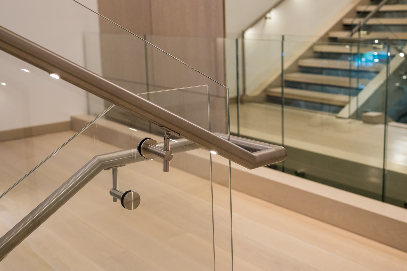 Detail of glass standoff fittings and handrail brackets on the monument stair glass railing